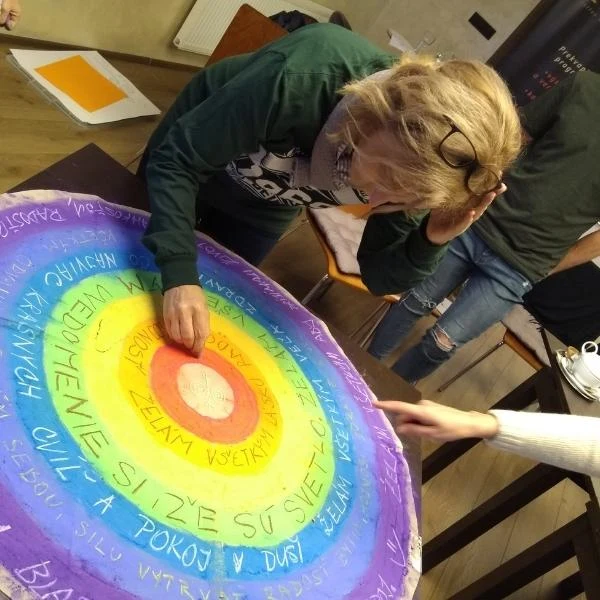 Účastníčka kurzu maľuje veľkú farebnú mandalu
